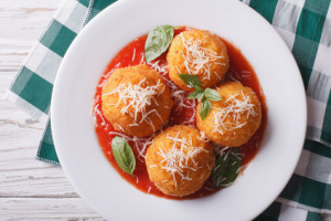 fried arancini rice balls with tomato sauce closeup. horizontal top view
